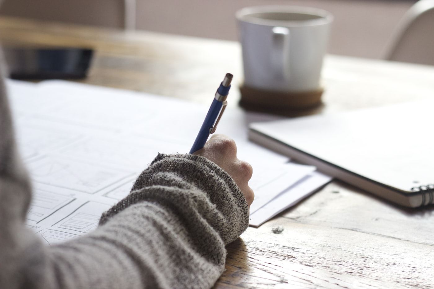 Hand annotating a content layout on paper — planning pages around search intent.